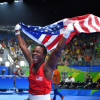 Clarissa Shields joyfully waving an American flag after securing a victory at the Olympics, embodying triumph and national pride.