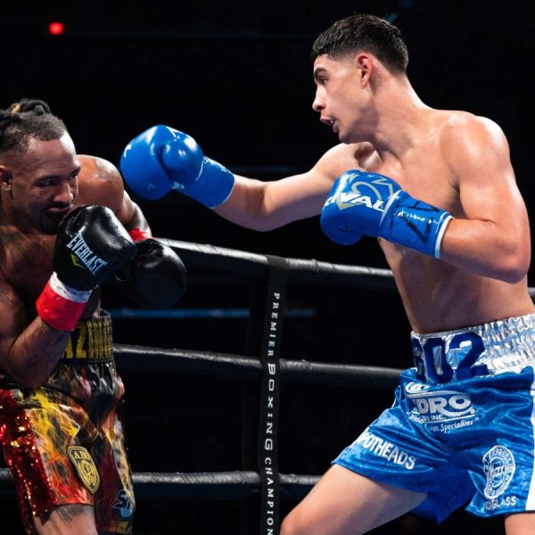 Elijah Garcia in a boxing ring, delivering a punch to an unidentified opponent