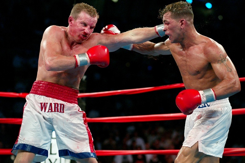 Arturo Gatti and Micky Ward captured mid-exchange, throwing punches with intense focus, in a closely contested boxing match.