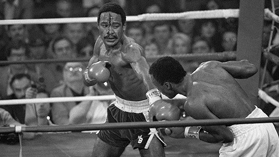 Wilfred Benitez, with blood streaming down his face, delivering a punch to a staggered Sugar Ray Leonard during a boxing match.