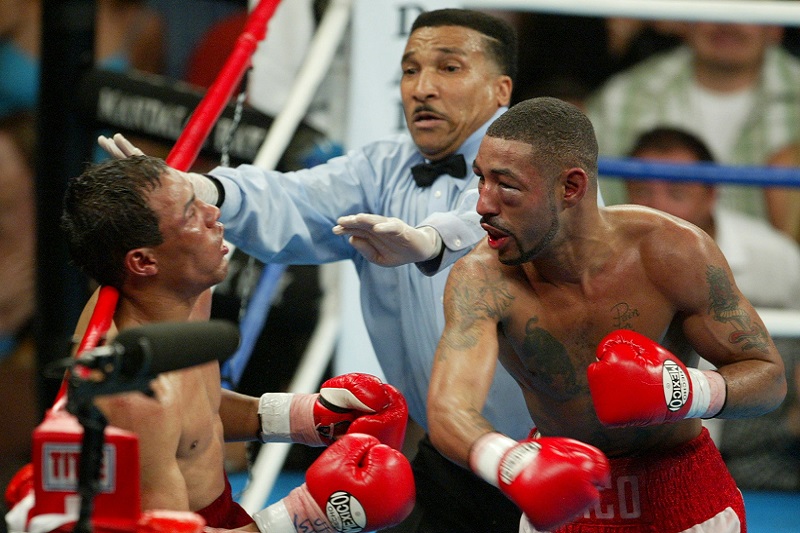 Action shot capturing the moment of the famous knockout in the Castillo vs. Corrales fight, with referee Tony Weeks rushing in to halt the bout.