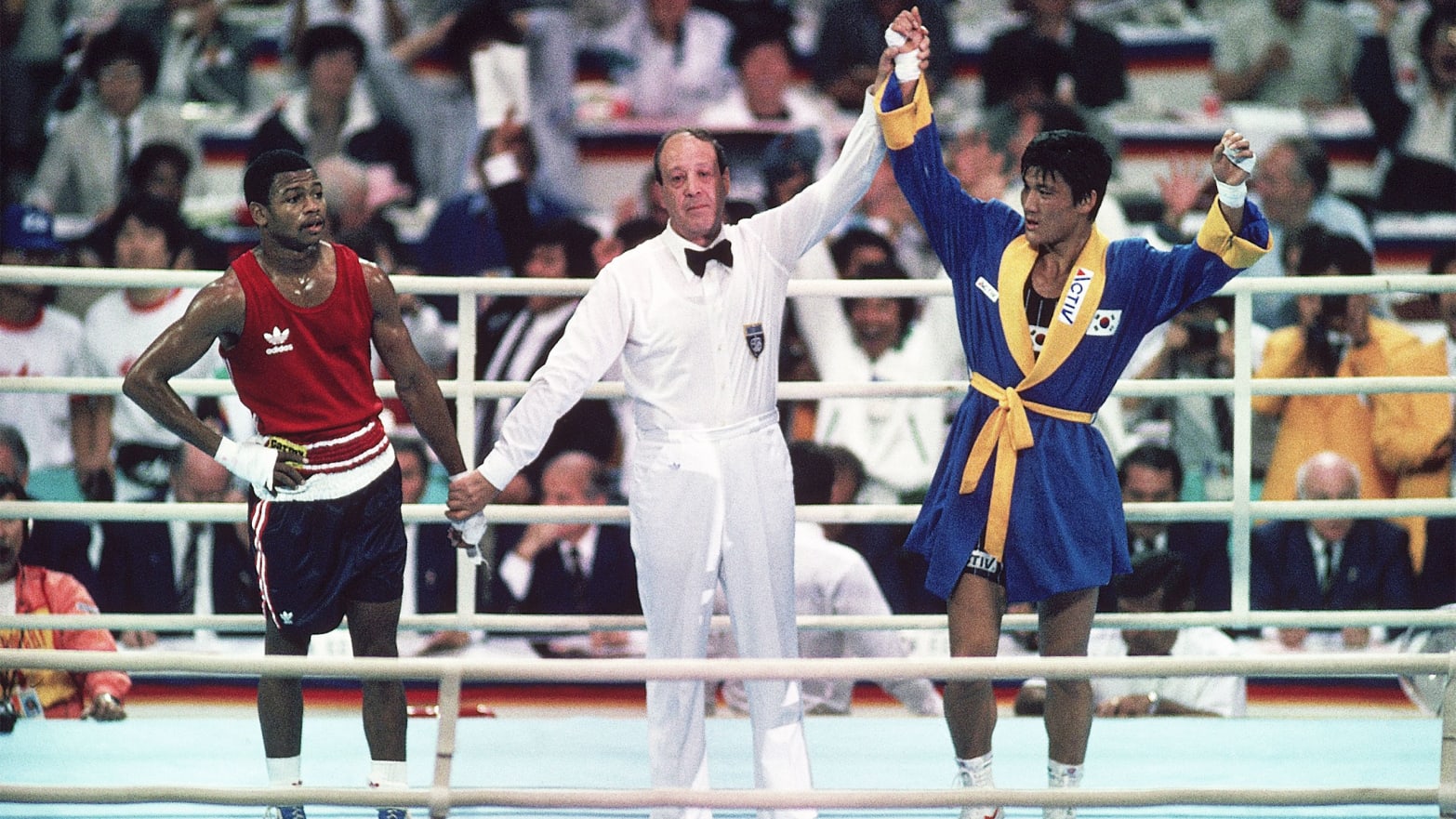 Referee raising Park Si-Hun's hand in victory after a controversial decision, despite Roy Jones Jr.'s clear dominance throughout the fight, capturing the surprise and disbelief in the arena.