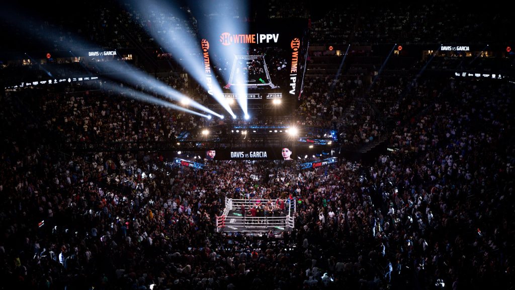Panoramic shot of the T-Mobile Arena, teeming with excited fans, for the Ryan Garcia vs. Tank Davis fight, capturing the electric atmosphere of the venue.